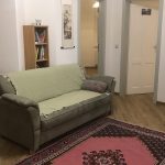 Wohnbereich mit Sofa gegenüber dem Fernseher in der Ferienwohnung Pfarrberg Eisenach