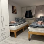 Ferienwohnung Karlstraße Eisenach – Schlafzimmer mit zwei Einzelbetten und Stehlampe