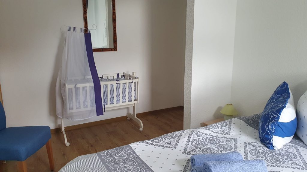 Schlafzimmer mit Babywippe in der Ferienwohnung Pfarrberg Eisenach