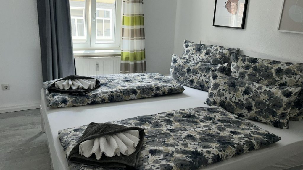 Ferienwohnung Karlstraße Eisenach – Schlafzimmer mit Doppelbett, Fenster und Vorhängen